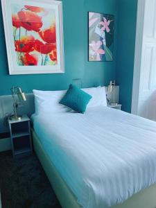 a bedroom with a large white bed with blue walls at Rose Lodge Guest House in Cork
