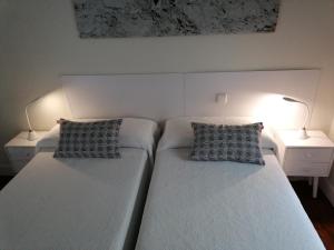 2 camas en un dormitorio con 2 lámparas en una mesa en Attic+views+terrace+parking, en San Sebastián