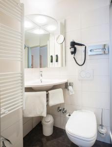 a white bathroom with a sink and a toilet at LIHO - einfach Lübeck in Lübeck