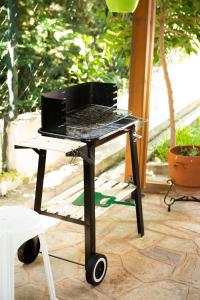 a barbecue grill on a cart on a patio at HOUSE WITH GARDEN Netflix in Néa Kerasiá