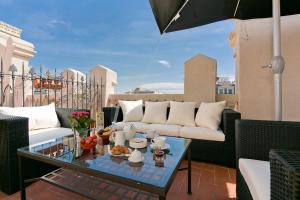 a patio with a couch and a glass table at Bcn Paseo De Gracia Rocamora Apartment in Barcelona