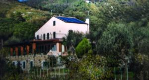 a white house with a blue roof on a hill at La Cabana Cinque Terre Monterosso in Monterosso al Mare