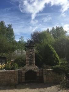 a brick fireplace in a yard with a stone wall at IOMAN HAUS in Ikšķile