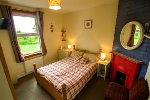 A bed or beds in a room at The Red Red Robin Cottage