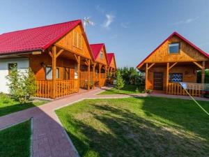 Zielona Dolina Rusinowo في ريوزينو: صف من البيوت الخشبية ذات السطوح الحمراء