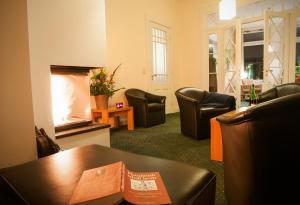 a waiting room with chairs and a table and a fireplace at LIHO - einfach Lübeck in Lübeck
