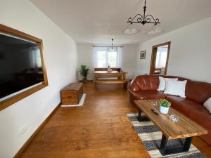 sala de estar con sofá de cuero marrón y mesa en Chalupa k pronajmutí Krásná Lípa u Rumburka, en Krásná Lípa
