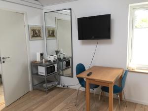 a room with a table and a desk with a television at BB-Risskov in Risskov