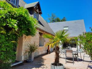 ein Haus mit einer Terrasse mit Stühlen und Pflanzen in der Unterkunft Les Hortensias-chambre chez l'habitant in Bretteville-du-Grand Caux