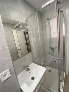 a white bathroom with a sink and a shower at Josep Tarradellas Entire Apartment in Sabadell