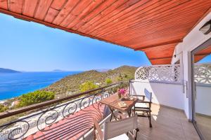 a balcony with a table and chairs and the ocean at Hamarat Otel in Kaş