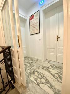 a hallway with a marble floor and a white door at Al Teatro in Reggio Calabria