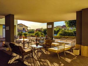 an outdoor patio with tables and chairs at Isa Residence Fiumicino Airport in Fiumicino