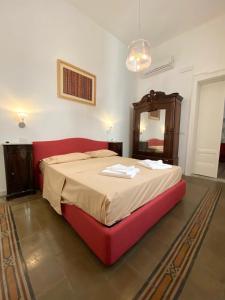 una camera con letto rosso e specchio di Al Teatro a Reggio di Calabria