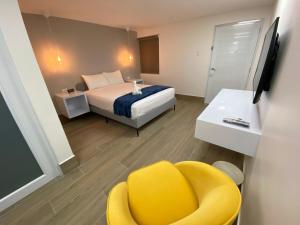 a hotel room with a bed and a yellow chair at Marina de Salinas in Salinas