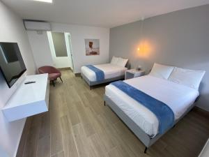 a hotel room with two beds and a television at Marina de Salinas in Salinas +70 photos