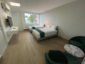 a bedroom with two beds and chairs and a window at Marina de Salinas in Salinas