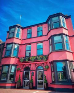 a pink building with windows and plants on it at Rose Lodge Guest House in Cork