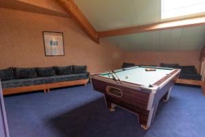 a living room with a pool table and a couch at Fasthotel Chateauroux in Déols