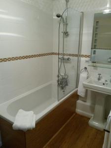 a bathroom with a shower and a tub and a sink at The Poldark Inn in Delabole
