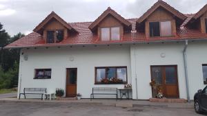 a white house with benches in front of it at Na samotě u lesa -Rasovna in Mšecké Žehrovice