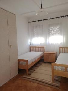 a bedroom with two beds and two windows at Trpejca Holiday Home in Trpejca