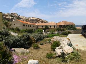 a building with rocks and plants in a yard at La Maddalena Apartment in La Maddalena