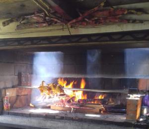 a grill with a bunch of food on fire at Rooms Ensar in Bihać