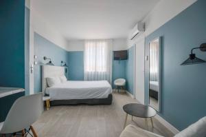 1 dormitorio con cama y pared azul en Abrivado en Saintes-Maries-de-la-Mer