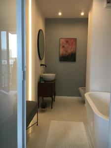 bagno con lavandino, servizi igienici e specchio di IVY Apartament a Varsavia