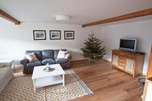 uma sala de estar com um sofá e uma árvore de Natal em Apartmány Český Jiřetín em Český Jiřetín