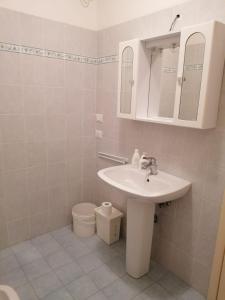 uma casa de banho branca com um lavatório e um WC em Little Star Pioppa em Riondi