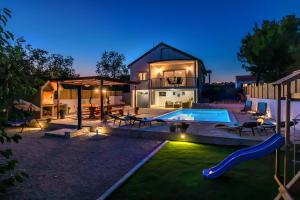 a backyard with a swimming pool and a house at Villa R&B heated pool in Vrpolje
