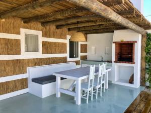 uma cozinha e sala de jantar com mesa e cadeiras em Cabana 2 da Comporta na Comporta