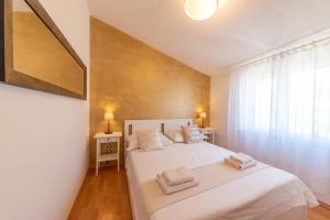 a bedroom with a large white bed and a window at Apartments Kristian in Bol