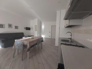uma cozinha e sala de estar com uma mesa e um sofá em Casa Bruna em Pimonte