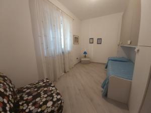 um pequeno quarto com uma cama e uma cadeira em Casa Bruna em Pimonte