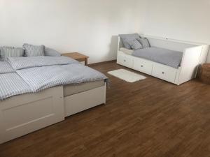 two beds in a room with wooden floors at Prázdninový dům Zavadilka in České Budějovice