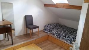 Habitación pequeña con cama y silla en maison bleue en Belfort