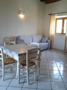 uma sala de estar com uma mesa e cadeiras e um sofá em La Maddalena Apartment em La Maddalena