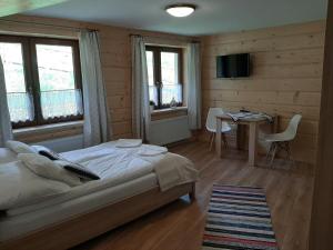 una camera da letto con un letto, un tavolo e delle sedie di Apartamenty i pokoje u Klimka a Zakopane