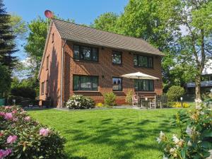 a brick house with a lawn in front of it at Heykens Golfhuus Albatros in Wiesmoor