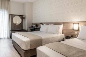 ラリサにあるHotel Parkのベッドが2つと鏡があるホテルの部屋 +103枚の写真