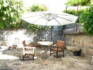 a table with an umbrella and chairs under an umbrella at Solar De Alarcao in Guarda