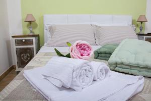 ein Bett mit Handtüchern und einer rosa Rose drauf in der Unterkunft B&B Le Camere di Livia in Siena