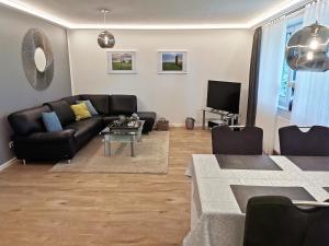 a living room with a couch and a table at Heykens Golfhuus Eagle in Wiesmoor