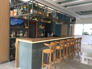 um bar com uma fila de bancos num quarto em Voula Hotel em Hersonissos