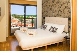 a bedroom with a bed with pillows and a window at LaPerla Premium in Sanxenxo