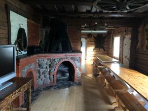 a living room with a brick fireplace and a tv at Sokka Holiday Center & Glamping in Otepää