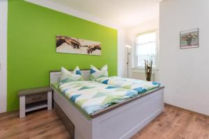 a bedroom with a bed with a green wall at Ferienwohnung Romy in Naumburg +9 photos